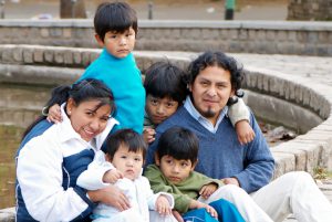 Happy Latin family sitting in the street